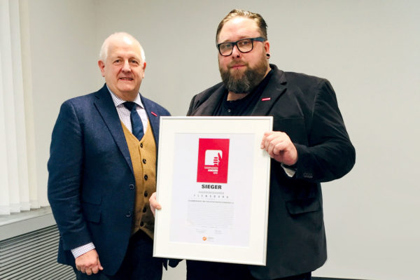 Tobias Grzesiak nahm den Kampagnen-Award 2018 von Joachim Wohlfeil (l.), Vorsitzender der AMH, entgegen. (Foto: AMH)